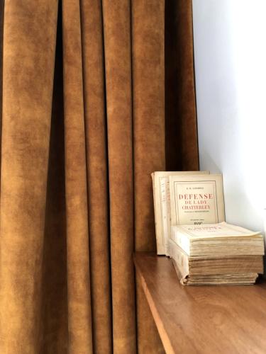 a book sitting on a table next to a curtain at Hotel De Verdun 1882, BW Signature Collection in Lyon