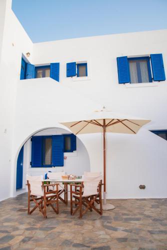a table and chairs with an umbrella in front of a building at Kanellis Studios in Avlemonas