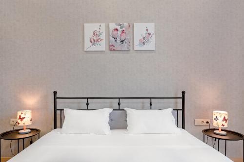 a bedroom with a bed with three paintings on the wall at Monument1880 in Tbilisi City
