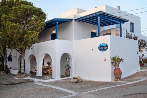 a white house with a blue roof at Kanellis Studios in Avlemonas