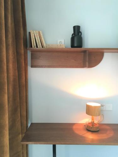 a lamp on a wooden table with a shelf at Hotel De Verdun 1882, BW Signature Collection in Lyon