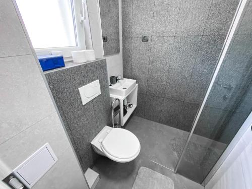 a small bathroom with a toilet and a shower at Apartment Light in Stobreč