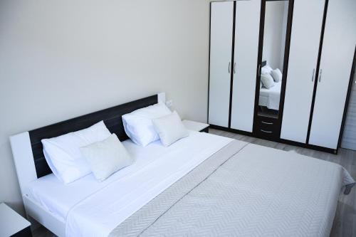 1 dormitorio con cama blanca y almohadas blancas en Apartment Light en Stobreč