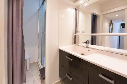 une salle de bain avec un lavabo et un miroir dans l'établissement 1 bedroom apartment with 1 mezzanine top location in the heart of Cannes, à Cannes
