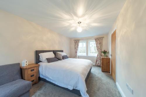 a bedroom with a bed and a couch at 8 Person-Luxury-FamilyFriendly-PetFriendly-Hot Tub in Hawick