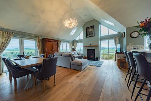 a dining room and living room with a table and chairs at 8 Person-Luxury-FamilyFriendly-PetFriendly-Hot Tub in Hawick