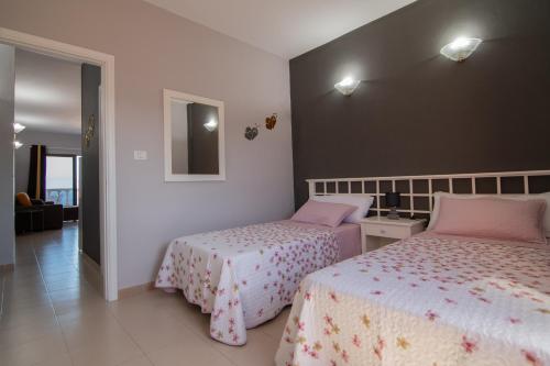 um quarto com 2 camas e um espelho em VV Norte y Sur em La Restinga