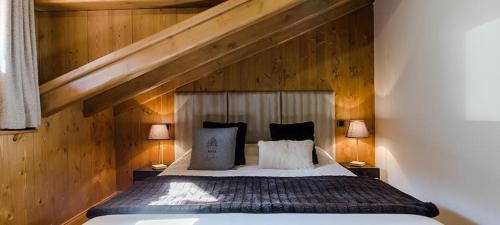 Schlafzimmer mit einem großen Bett und Holzwänden in der Unterkunft Appart 6 pers centre Le Praz - Los Robles in Courchevel