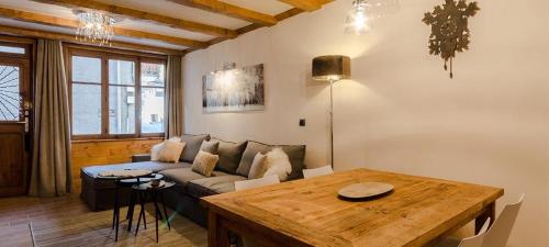 ein Wohnzimmer mit einem Sofa und einem Tisch in der Unterkunft Appart 6 pers centre Le Praz - Los Robles in Courchevel