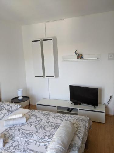 a bedroom with a bed and a flat screen tv at Apartment Fugosic in Šilo