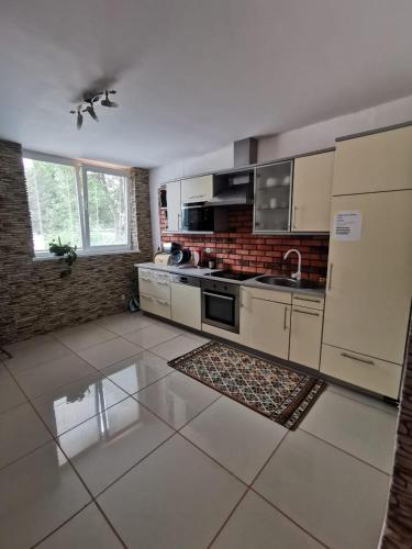 a kitchen with white appliances and a tile floor at APARTMENTS V+K in Tatranska Strba