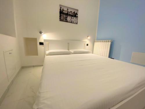 a large white bed in a white room at Nicolaus in Sesto Calende
