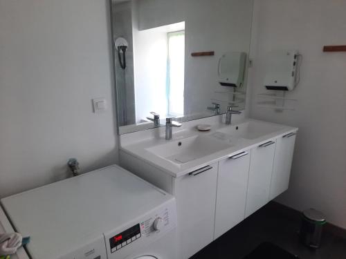 a white bathroom with two sinks and a mirror at appartement 150 M2 tout confort 4 chambres in Noidans-le-Ferroux