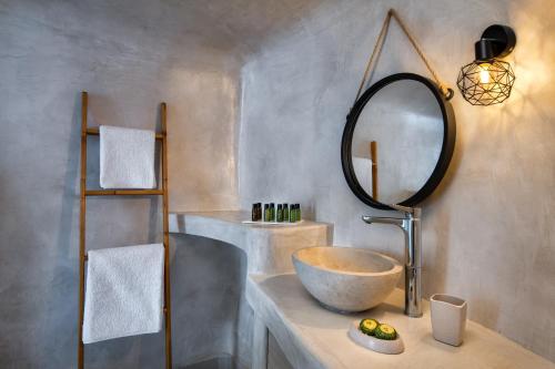 a bathroom with a bowl sink and a mirror at Aegean Mist Luxury Suites in Megalokhori