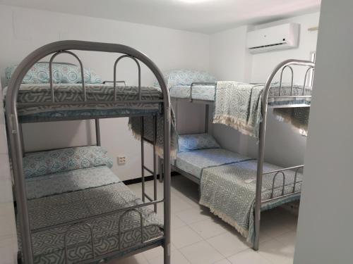 a room with two bunk beds and a staircase at Monísimo Pensión Rincón de la Victoria in Rincón de la Victoria