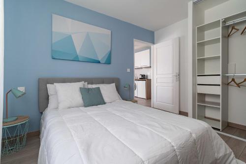 een slaapkamer met een groot bed met een blauwe muur bij Cocoon Appart 1 Miribel in Miribel