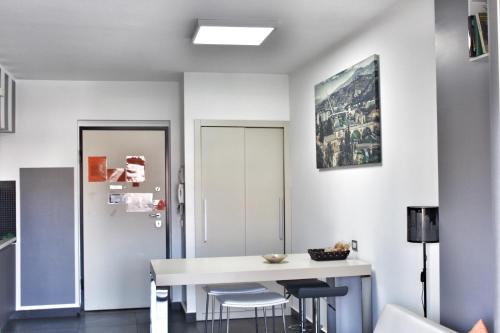una sala da pranzo con un tavolo bianco e sgabelli di Cosenza Luxury Apartment a Cosenza