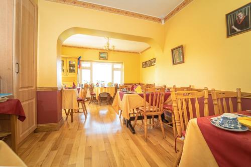 a restaurant with tables and chairs with yellow walls at Bertra House B&B in Westport