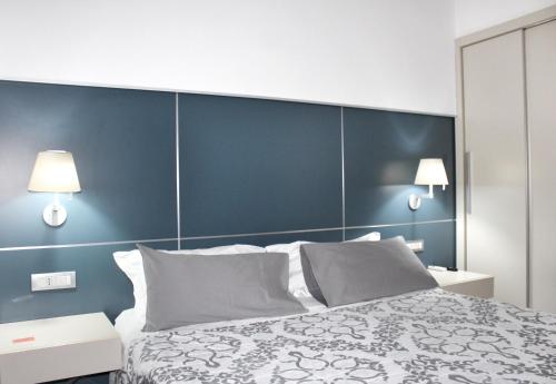 una camera da letto con un letto grande con una parete blu di Cosenza Luxury Apartment a Cosenza