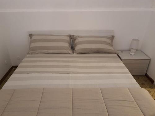 Ce lit se trouve dans une chambre dotée d'un mur blanc. dans l'établissement Maison Mafalda, à Surbo