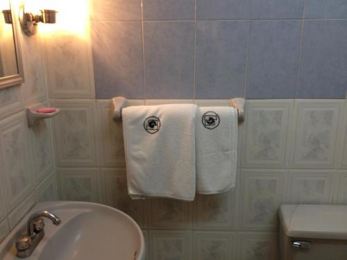 a bathroom with white towels hanging on a wall at Hotel Gomez de Celaya in Celaya