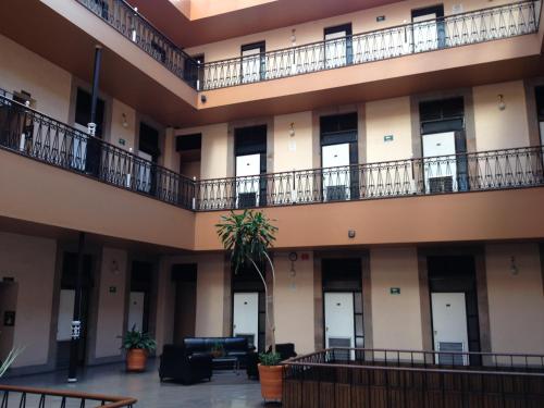 an empty lobby of a building with balconies at Hotel Gomez de Celaya in Celaya