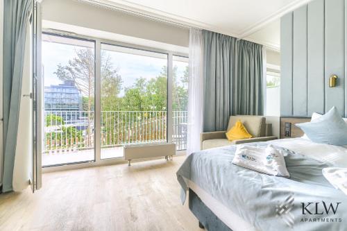 ein Schlafzimmer mit einem Bett und einem großen Fenster in der Unterkunft Lividus 307 Świnoujscie ApartPark - KLW apartments AC in Świnoujście