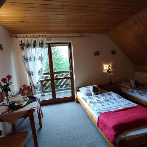 a bedroom with a bed and a window and a table at Agroturystyka nad brzegiem in Kacwin