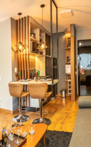 a kitchen with a bar with wine glasses on a table at 806 - Rentaqui - Flat Studio Bela Cintra Elegance - Consolação in Sao Paulo