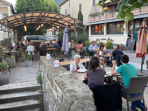 a group of people sitting at a table in a restaurant at La Vieille Auberge in Vesc