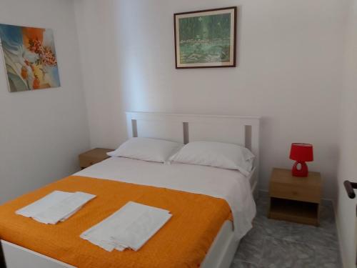 ein Schlafzimmer mit einem Bett mit einer orangefarbenen Decke in der Unterkunft Appartamento in villa .. in Peschici