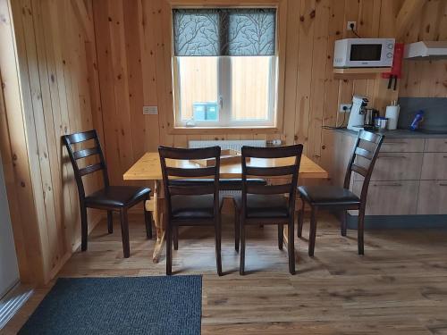 cocina con mesa de madera y sillas en una habitación en Greystone summerhouse, en Egilsstadir