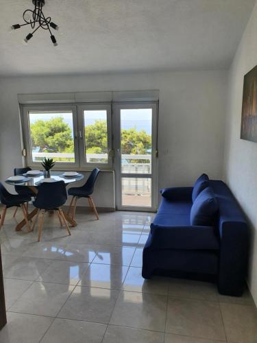 a living room with a blue couch and a table at LEGIN in Živogošće