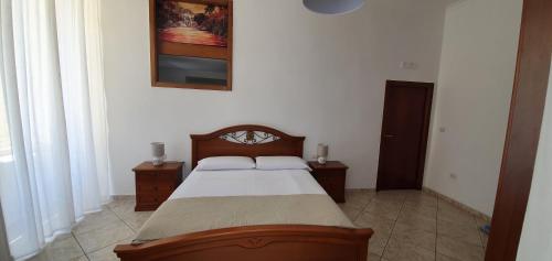 een slaapkamer met een bed en twee tafels en een foto aan de muur bij la casa di Maya in Napels