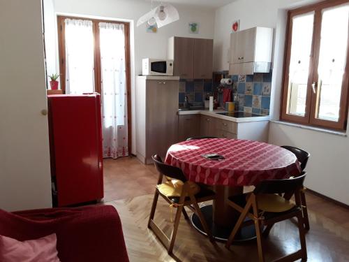a kitchen with a table and a red refrigerator at Appartamento Fantasia CIR Aosta 0241 in Aosta