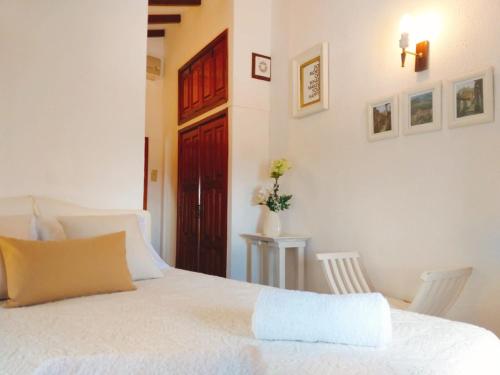 a bedroom with a white bed and a red door at Casa dos Sequeiras in Monsanto
