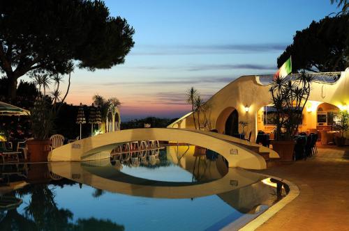 a bridge over a pool of water at night at Hotel Terme Villa Teresa in Ischia