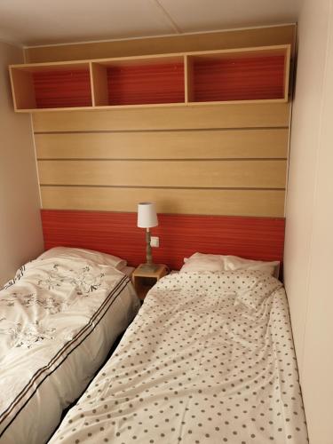 - 2 lits jumeaux dans une chambre avec une tête de lit dans l'établissement Biscarrosse lac Mobil home tout confort, à Biscarrosse