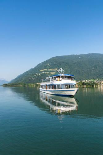 a white boat floating on a large body of water at APARTMENT WALD - im Skigebiet Gerlitzen & Ossiacher See in Bodensdorf