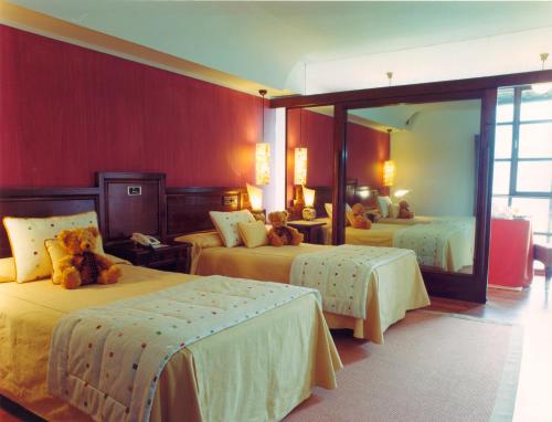 um quarto com três camas com ursos de peluche em La Rectoral em Taramundi