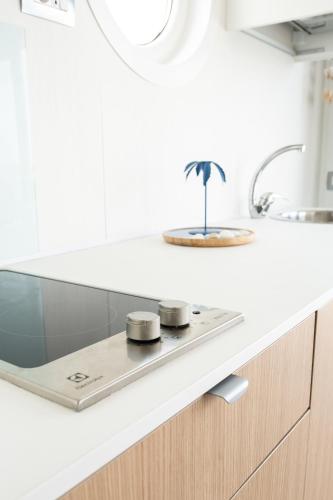 a kitchen counter with a stove with a palm tree on it at House Boat Rimini Resort in Rimini
