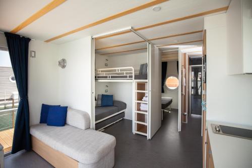 a small bedroom with a bunk bed and blue pillows at House Boat Rimini Resort in Rimini