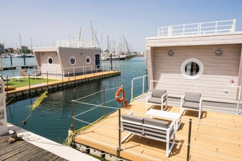 a boat with two chairs sitting on a dock at House Boat Rimini Resort in Rimini
