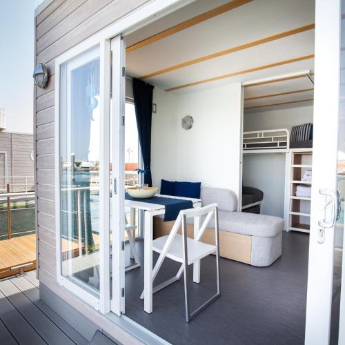 a room with a balcony with a table and chairs at House Boat Rimini Resort in Rimini