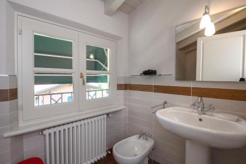 a bathroom with a sink and a toilet and a window at Relais Villa Isabel in Pietrasanta
