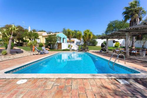 a large swimming pool in a yard with a house at Casa De Mondo in Boliqueime