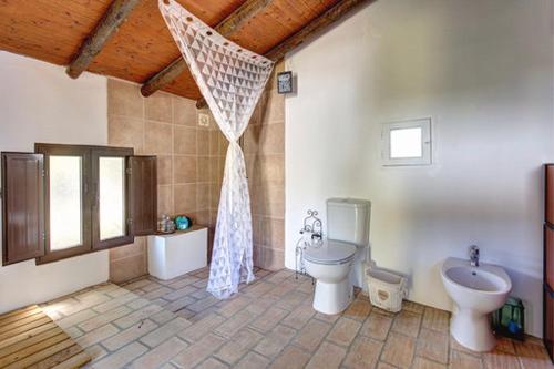 a large bathroom with a toilet and a sink at Casa De Mondo in Boliqueime