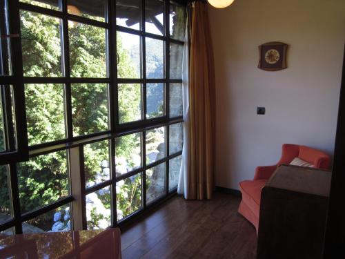 a living room with large windows and a red couch at La Rectoral in Taramundi