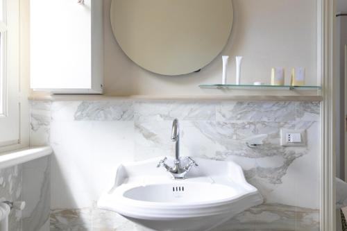 a bathroom with a white sink and a mirror at Relais Villa Isabel in Pietrasanta
