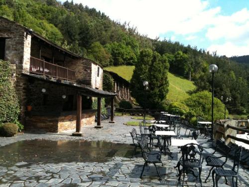 a patio with chairs and tables and a building at La Rectoral in Taramundi